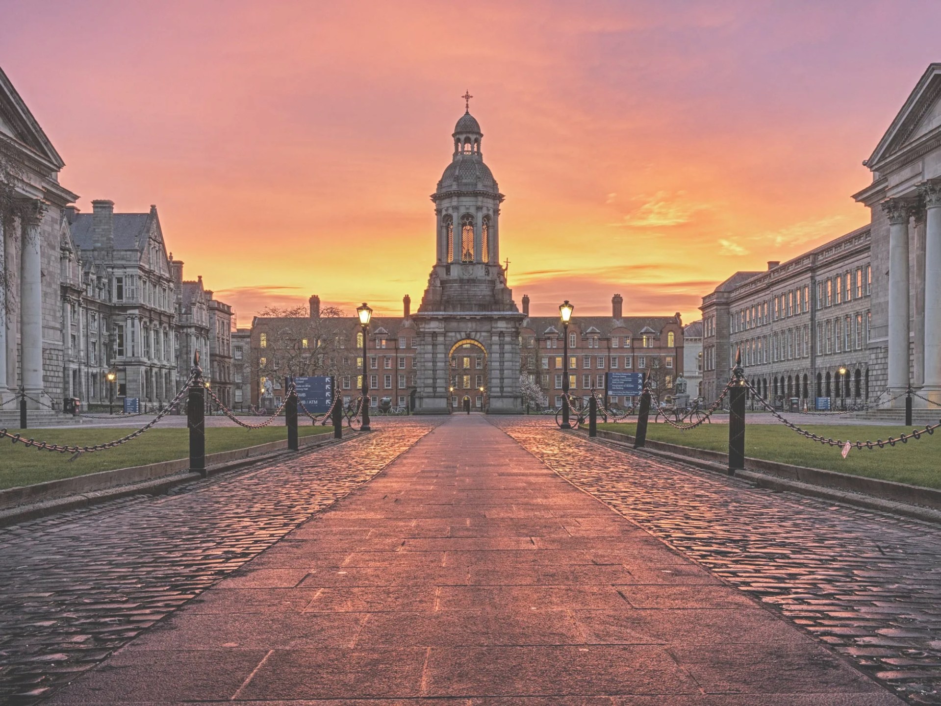 A picture of Trinity College Campus with a beautiful sunset backdrop of purple, yellow, orange and pink