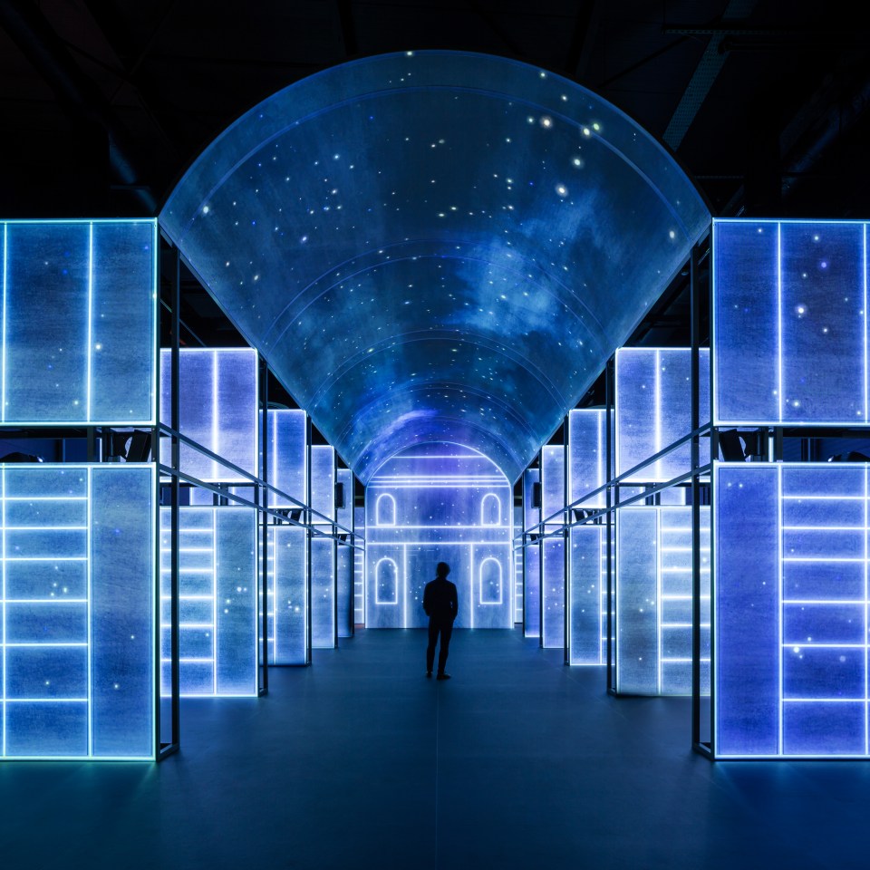 A person standing in the middle of an interactive display at the Book of Kells Experience.
