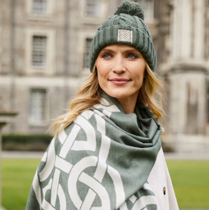 Woman with blonde hair wearing a mint green winter hat, with a mint green Celtic-inspired scarf.